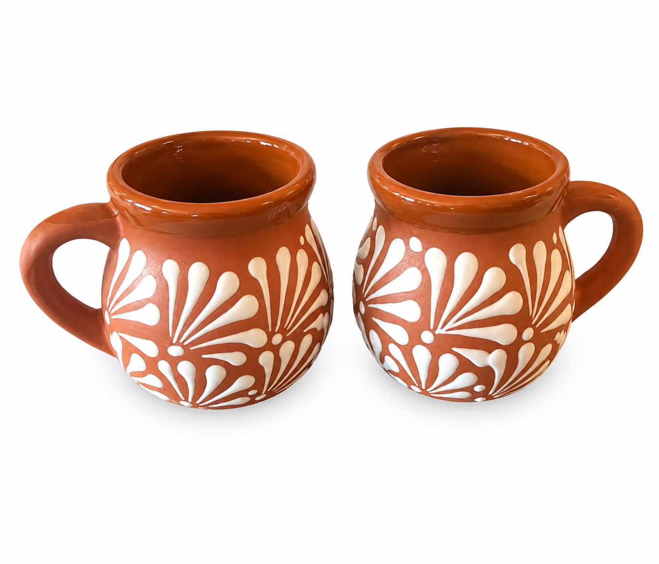 Two terracotta mugs with white floral patterns on a white background